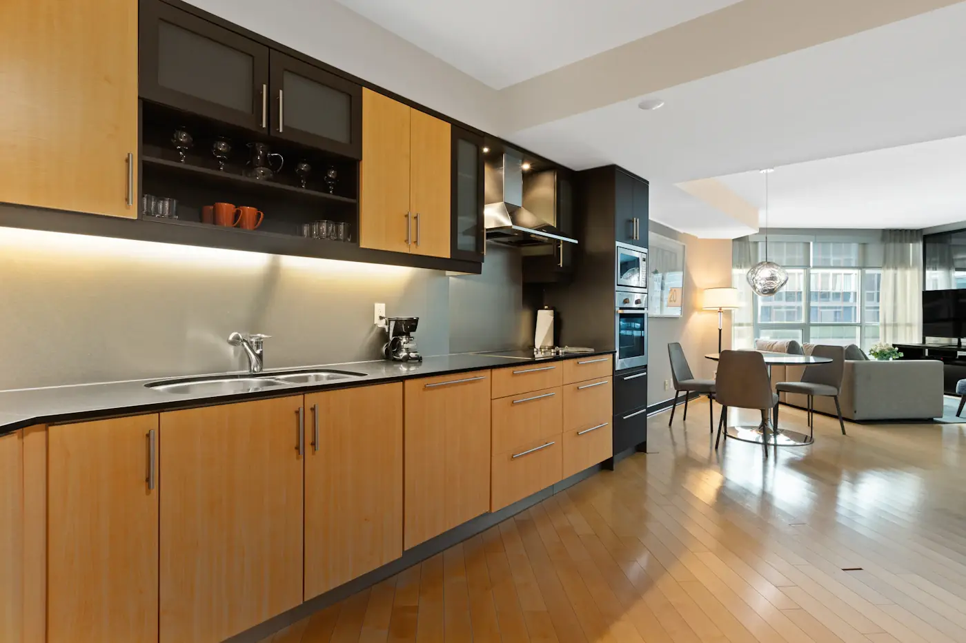 A timber kitchen with dark benchtops and under-cabinet lighting
