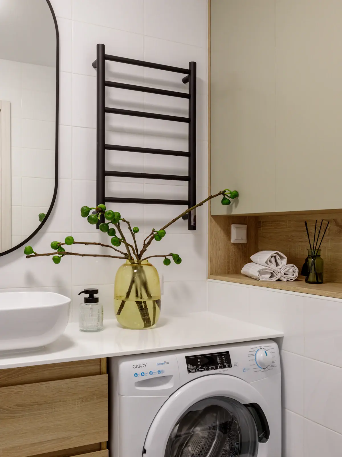 A bright laundry with timber shelving, a sink and a towel rail