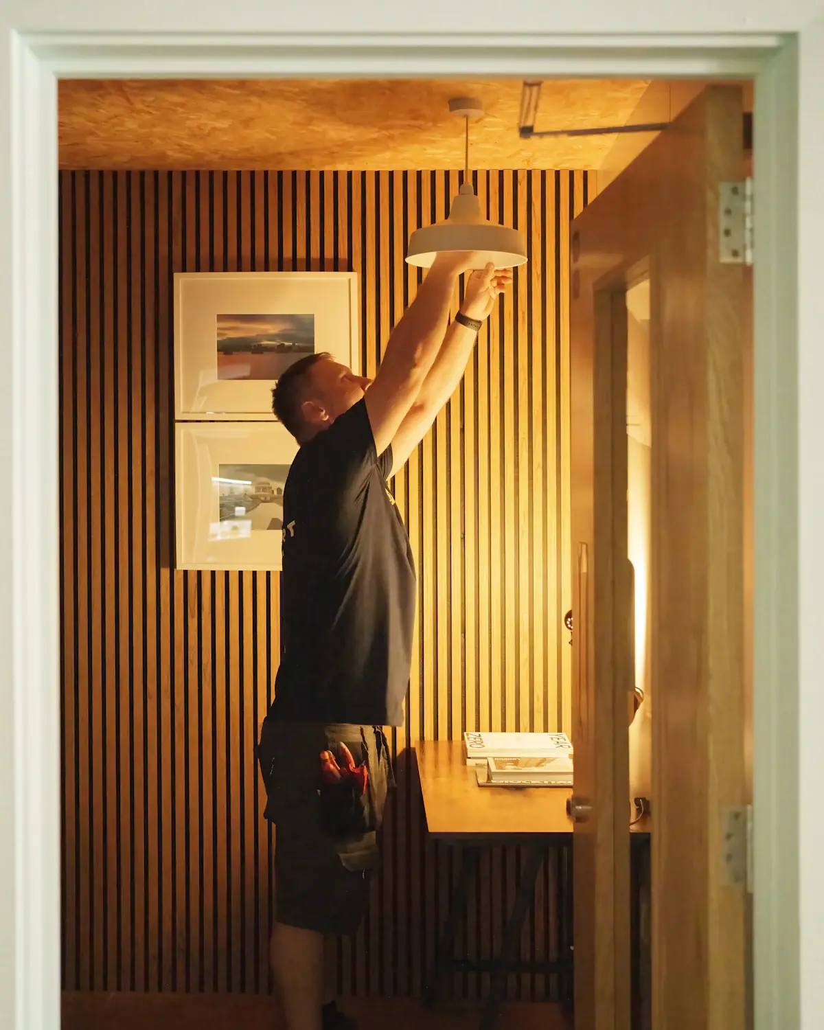 A tradesperson adjusting a pendant light